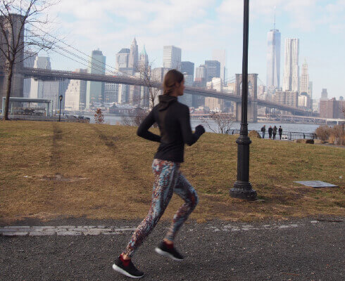 ブルックリン ブルックリン橋が見える公園でジョギングする女性